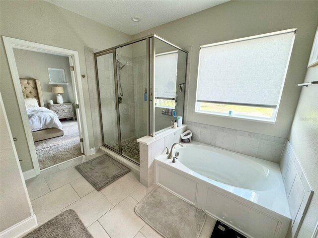 full bathroom featuring a stall shower, a textured ceiling, ensuite bath, tile patterned flooring, and a bath