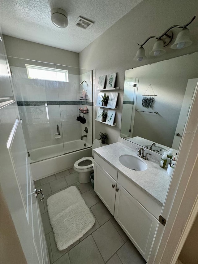 bathroom featuring visible vents, toilet, shower / bath combination with glass door, tile patterned floors, and a textured ceiling