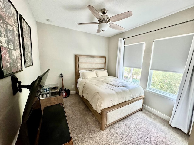 carpeted bedroom with ceiling fan and baseboards