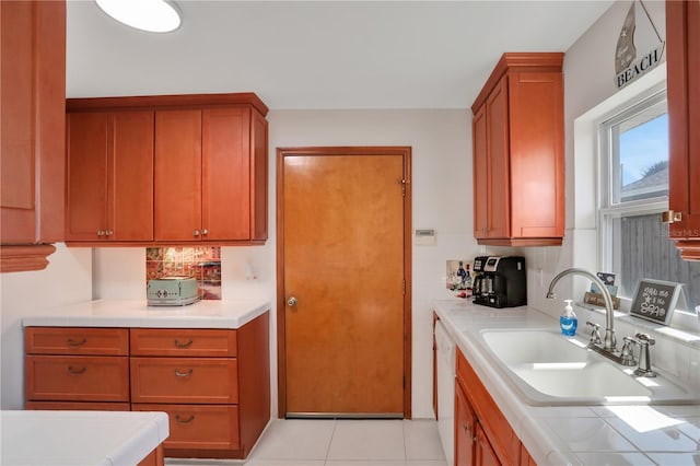 44 Capistrano Dr, Ormond Beach, FL 32176 - kitchen featuring light tile patterned floors, tile counters, brown cabinets, and a sink