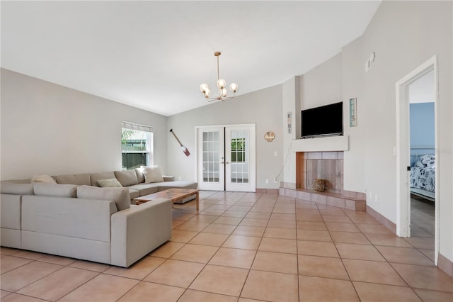 44 Capistrano Dr, Ormond Beach, FL 32176 - living area featuring french doors, light tile patterned floors, a tiled fireplace, vaulted ceiling, and a chandelier