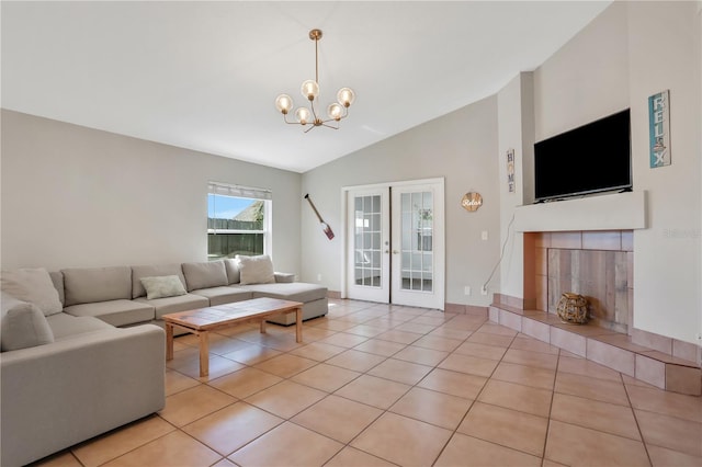 44 Capistrano Dr, Ormond Beach, FL 32176 - living area featuring light tile patterned floors, high vaulted ceiling, a fireplace, french doors, and an inviting chandelier