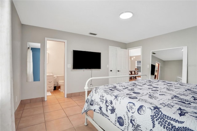 44 Capistrano Dr, Ormond Beach, FL 32176 - bedroom featuring ensuite bathroom, light tile patterned flooring, visible vents, and baseboards