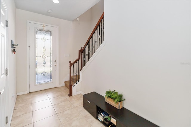 entrance foyer featuring stairs, baseboards, and light tile patterned flooring