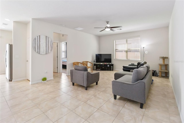 living room with a ceiling fan, visible vents, baseboards, and light tile patterned floors