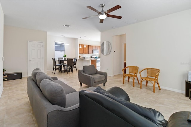 living room with light tile patterned floors, baseboards, visible vents, and a ceiling fan