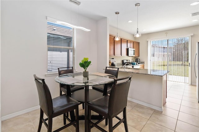 dining area featuring light tile patterned floors, recessed lighting, and baseboards