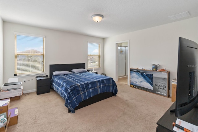 bedroom featuring a textured ceiling, carpet floors, and visible vents