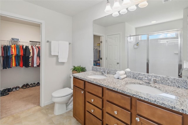 bathroom with a sink, a shower stall, toilet, and a spacious closet