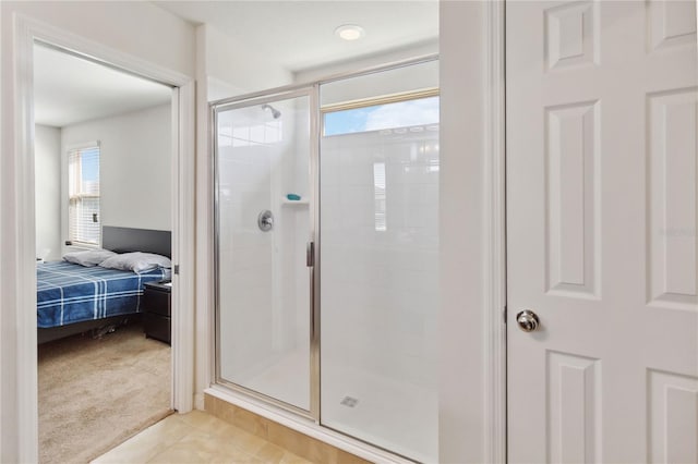 full bath with tile patterned flooring, plenty of natural light, a shower stall, and ensuite bath