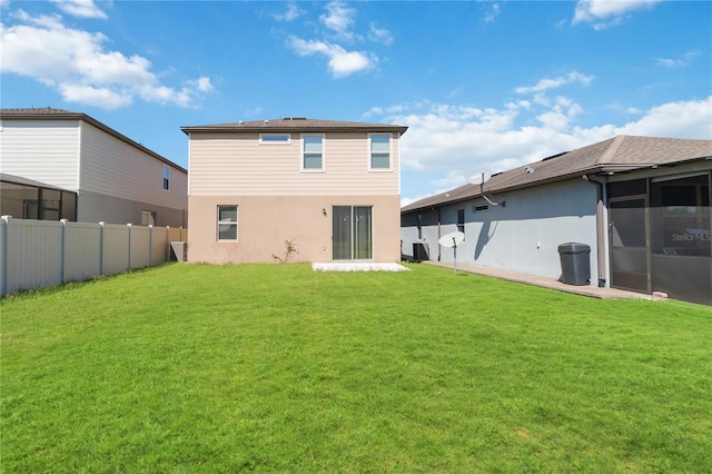 rear view of property with a yard, fence, and a sunroom