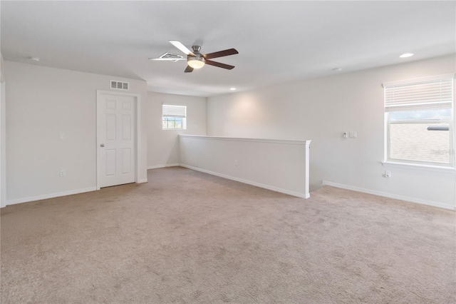 unfurnished room with baseboards, visible vents, and light colored carpet