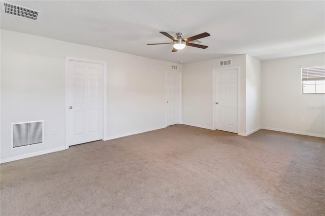 empty room with carpet flooring, visible vents, and baseboards