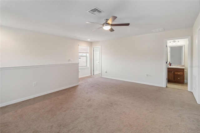 spare room with light carpet, baseboards, visible vents, and ceiling fan