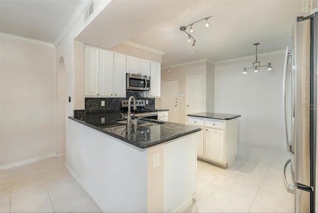 kitchen featuring arched walkways, stainless steel appliances, visible vents, decorative backsplash, and crown molding