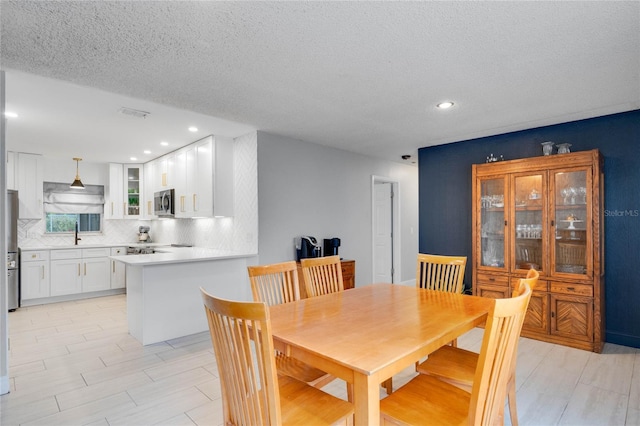 dining room with a textured ceiling and recessed lighting