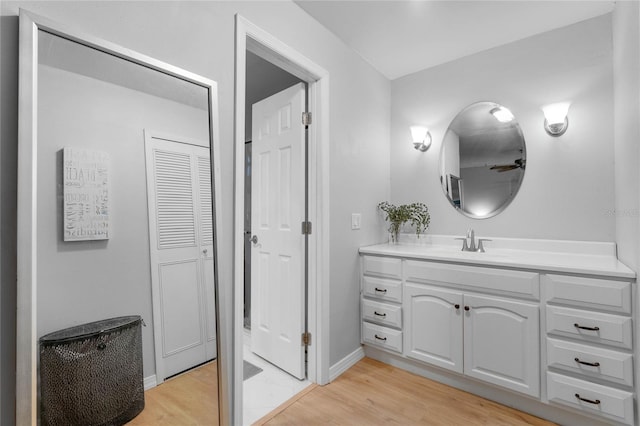 bathroom featuring vanity, baseboards, and wood finished floors