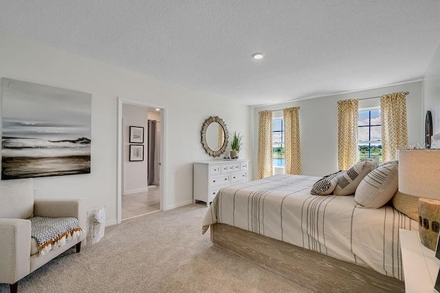 bedroom with a textured ceiling, carpet flooring, and baseboards