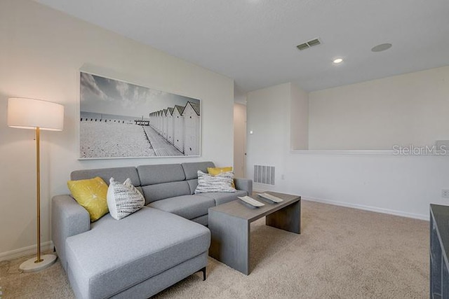 carpeted living room featuring baseboards, visible vents, and recessed lighting