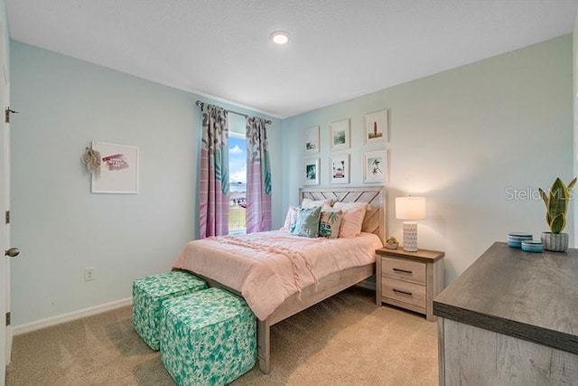 bedroom featuring baseboards and light colored carpet