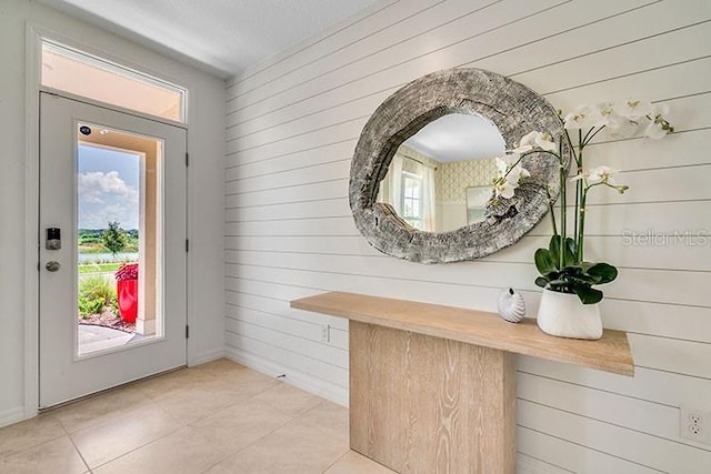 doorway with light tile patterned floors and a wealth of natural light