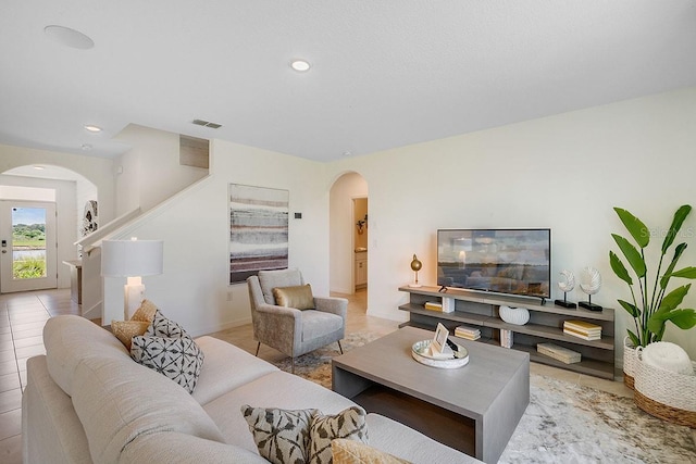 living room with visible vents, arched walkways, and recessed lighting