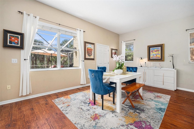 dining room with wood finished floors, a wealth of natural light, and baseboards