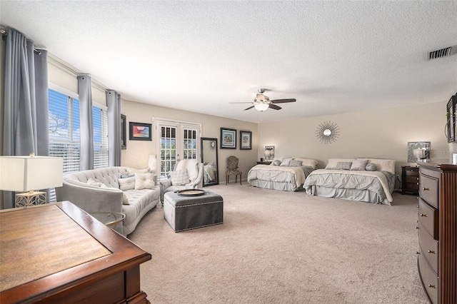 carpeted bedroom featuring ceiling fan, visible vents, a textured ceiling, and french doors