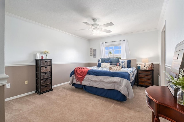 carpeted bedroom featuring ornamental molding, ceiling fan, a textured ceiling, and baseboards