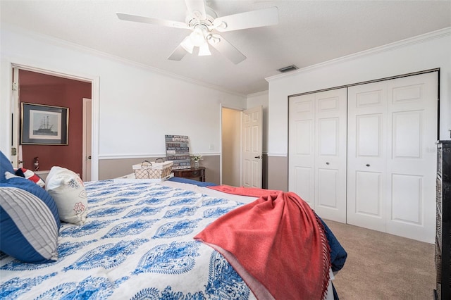 carpeted bedroom with a ceiling fan, a closet, visible vents, and crown molding