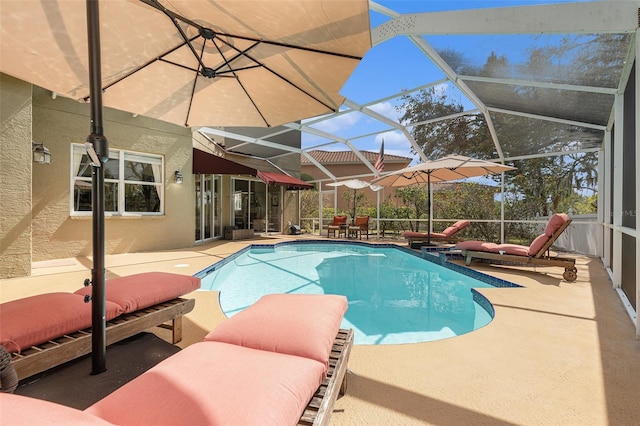 pool with glass enclosure and a patio area