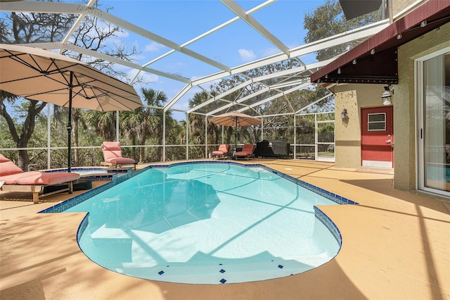 view of pool featuring glass enclosure, a patio area, and a pool with connected hot tub