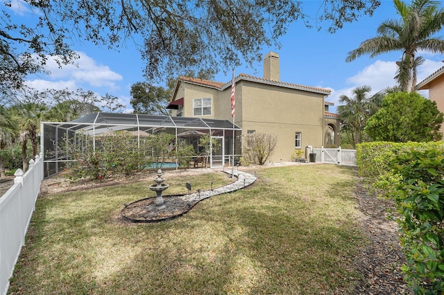 back of house featuring a tiled roof, a chimney, a fenced backyard, and stucco siding