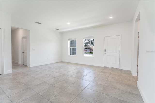 empty room with recessed lighting, visible vents, and baseboards