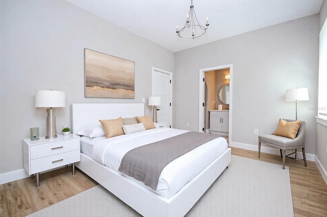 bedroom with an inviting chandelier, light wood-style flooring, baseboards, and ensuite bathroom