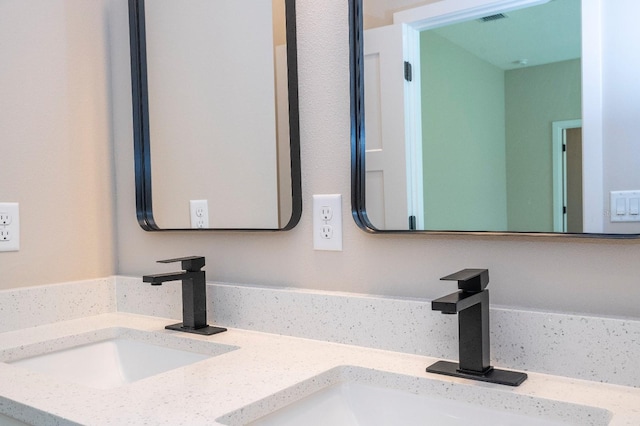 interior details with visible vents, a sink, and double vanity