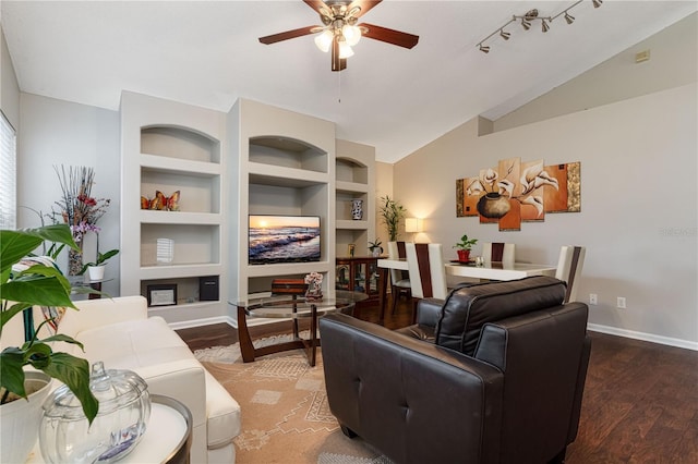 living room with baseboards, built in features, lofted ceiling, ceiling fan, and wood finished floors