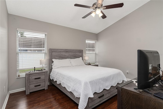 bedroom featuring lofted ceiling, multiple windows, dark wood finished floors, and baseboards