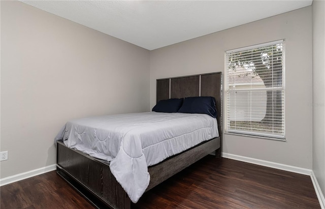 bedroom with wood finished floors and baseboards