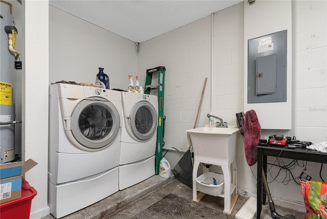 laundry room with concrete block wall, electric panel, independent washer and dryer, and water heater