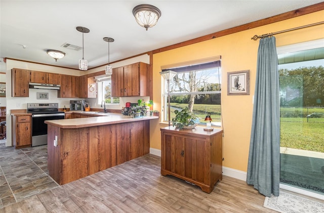 kitchen with under cabinet range hood, visible vents, brown cabinetry, and electric stove