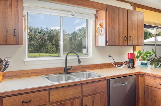 kitchen with a sink, plenty of natural light, light countertops, and dishwasher