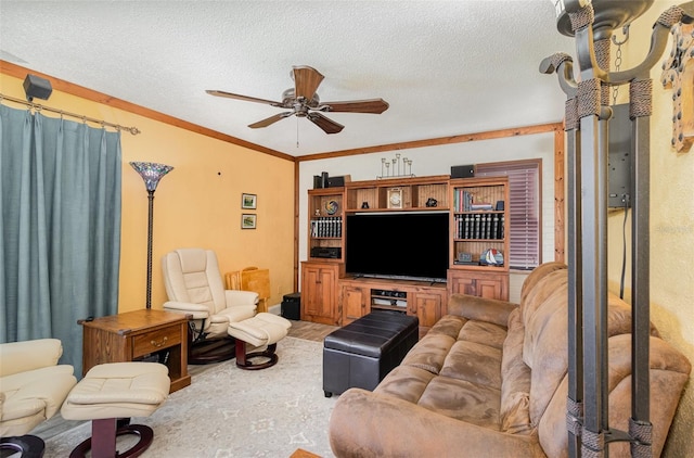 living area featuring a ceiling fan, ornamental molding, and a textured ceiling