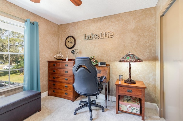 carpeted office featuring baseboards and a ceiling fan