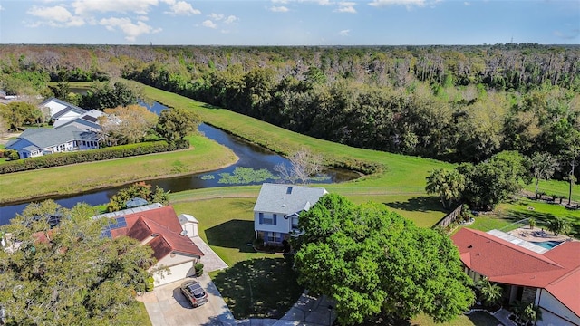 birds eye view of property with a water view and a wooded view