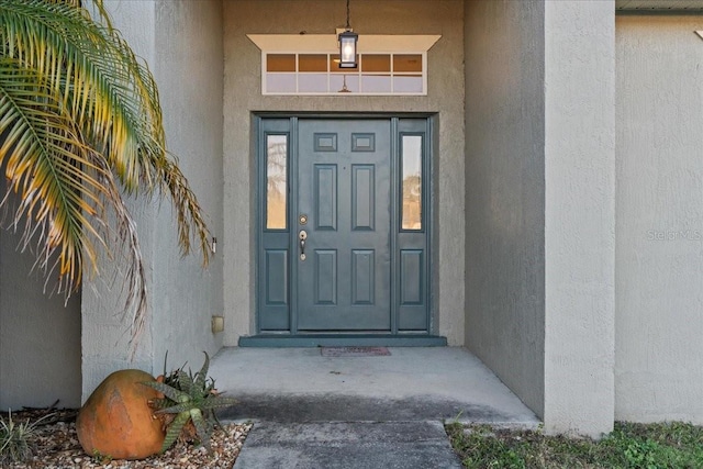 view of exterior entry featuring stucco siding