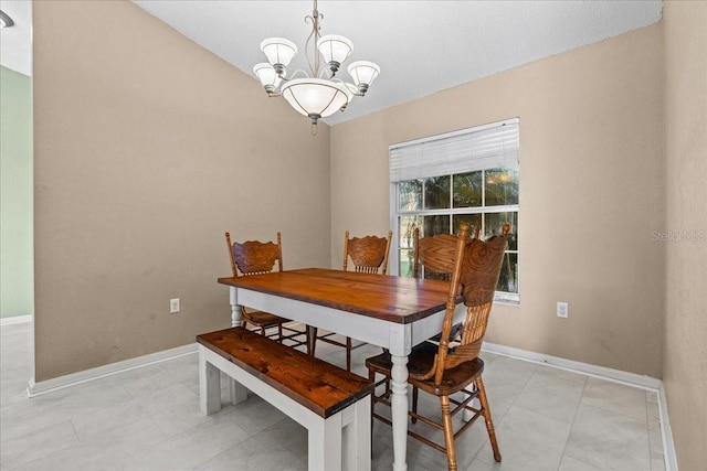 dining area featuring a notable chandelier and baseboards