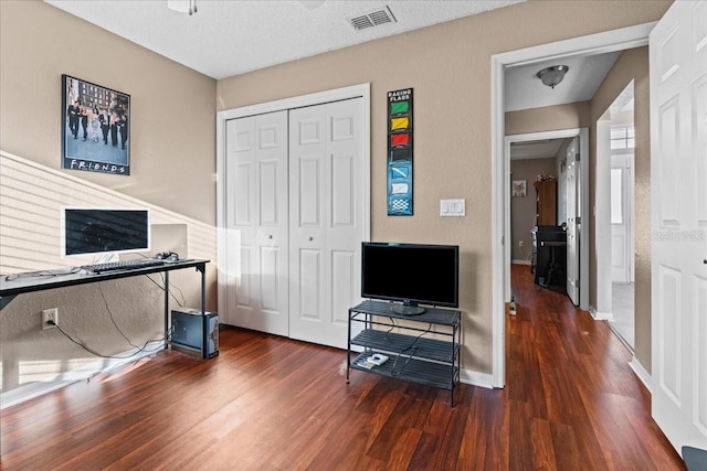 office area featuring visible vents, baseboards, a textured ceiling, and wood finished floors