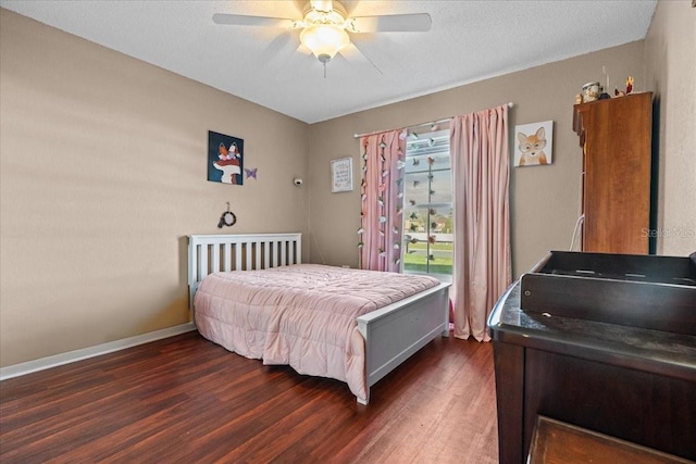 bedroom with a textured ceiling, a ceiling fan, dark wood-type flooring, and baseboards