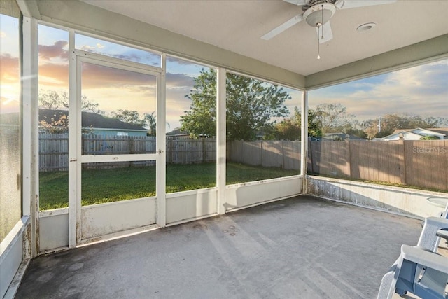 unfurnished sunroom with ceiling fan